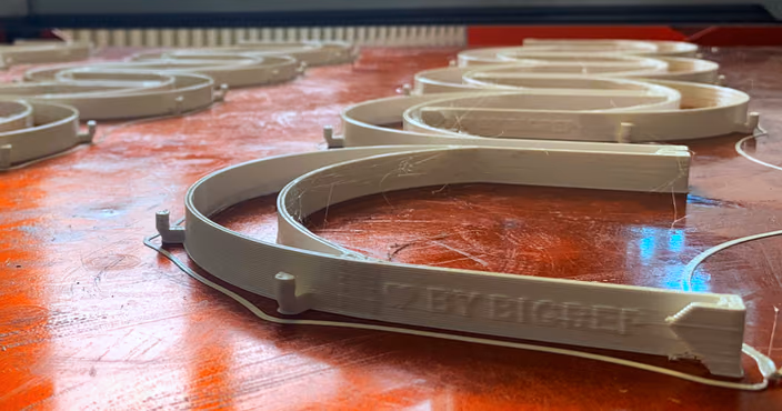 3D-printed face shield frame components on a workshop surface