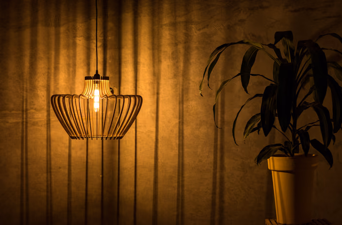 A hanging Shapelamp pendant with vertical ribbed design illuminated in an interior setting