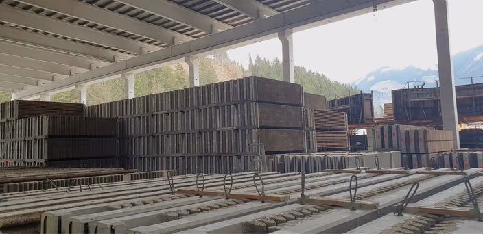 Manufacturing facility showing hundreds of stacked concrete wall panels of various sizes and shapes ready for storage and shipment.