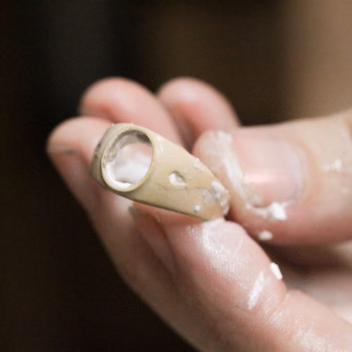 Wax jewelry model held in hand showing the fine detail created in lost wax casting.