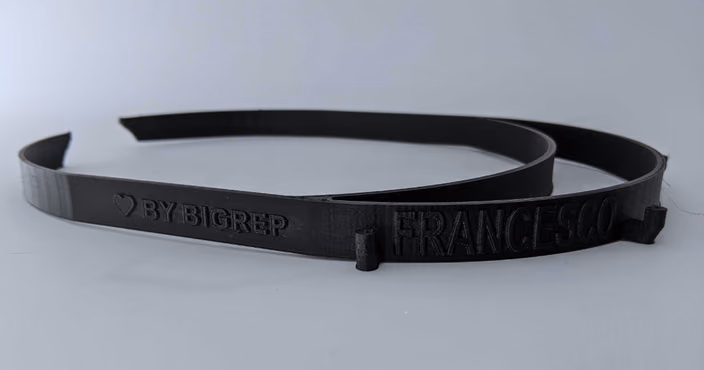 Black 3D-printed face shield with BigRep branding and personalized text embossed
