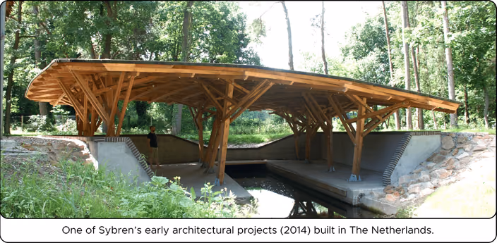 Wooden pavilion with curved roof spanning over water in a forest landscape setting