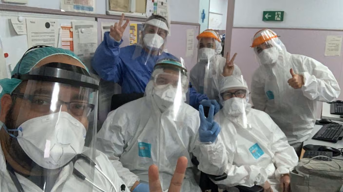 Group of healthcare workers wearing 3D-printed face shields and protective equipment